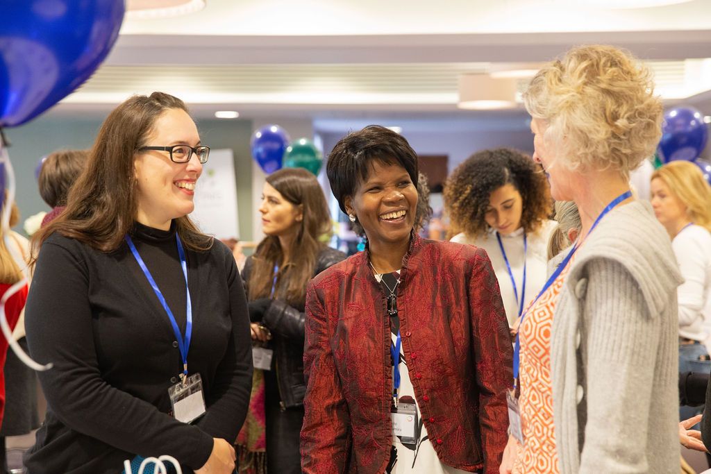 Three women laughing together at a Horizon Collective event