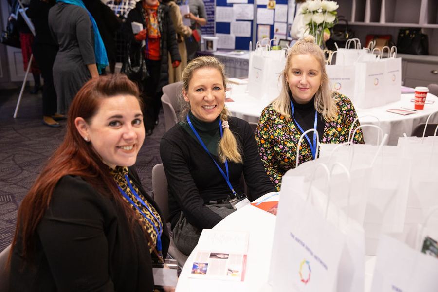 Three women smiling at their table